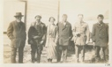 Image of Woman and five men by building